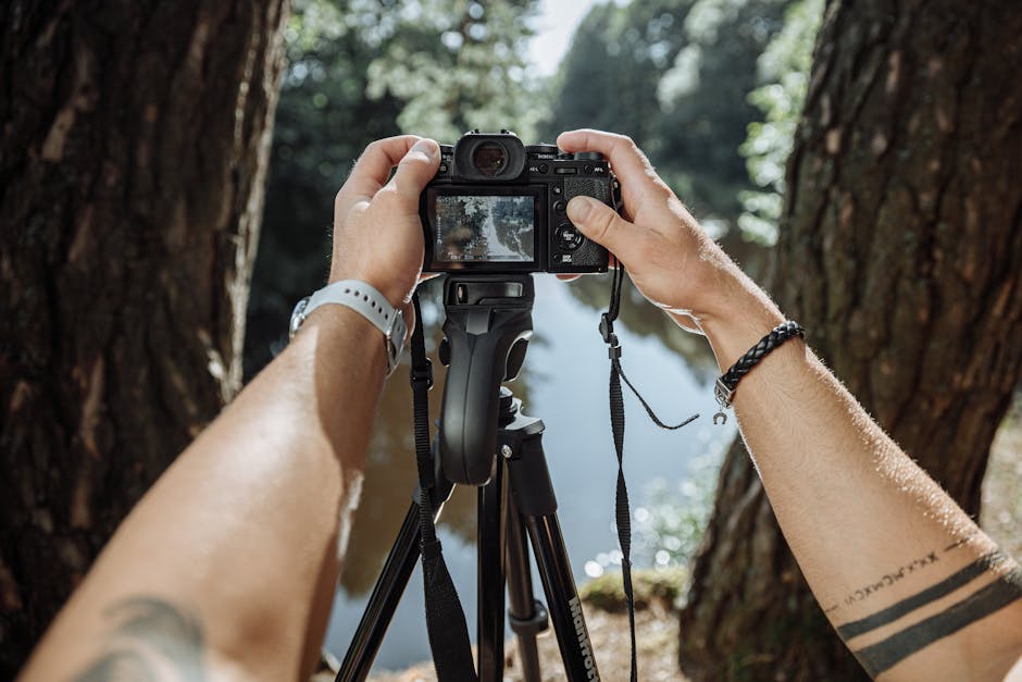 Mains réglant un appareil sur trépied pour photographier des gorges en Sicile