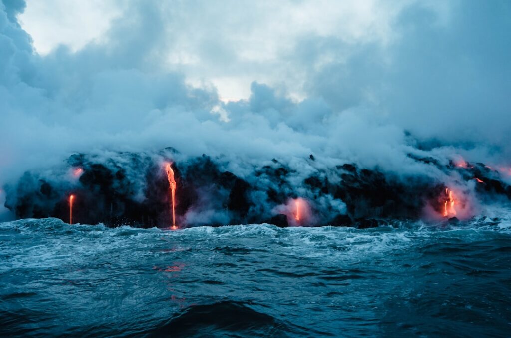 Colate di lava incandescenti che si versano nel mare con fumo denso