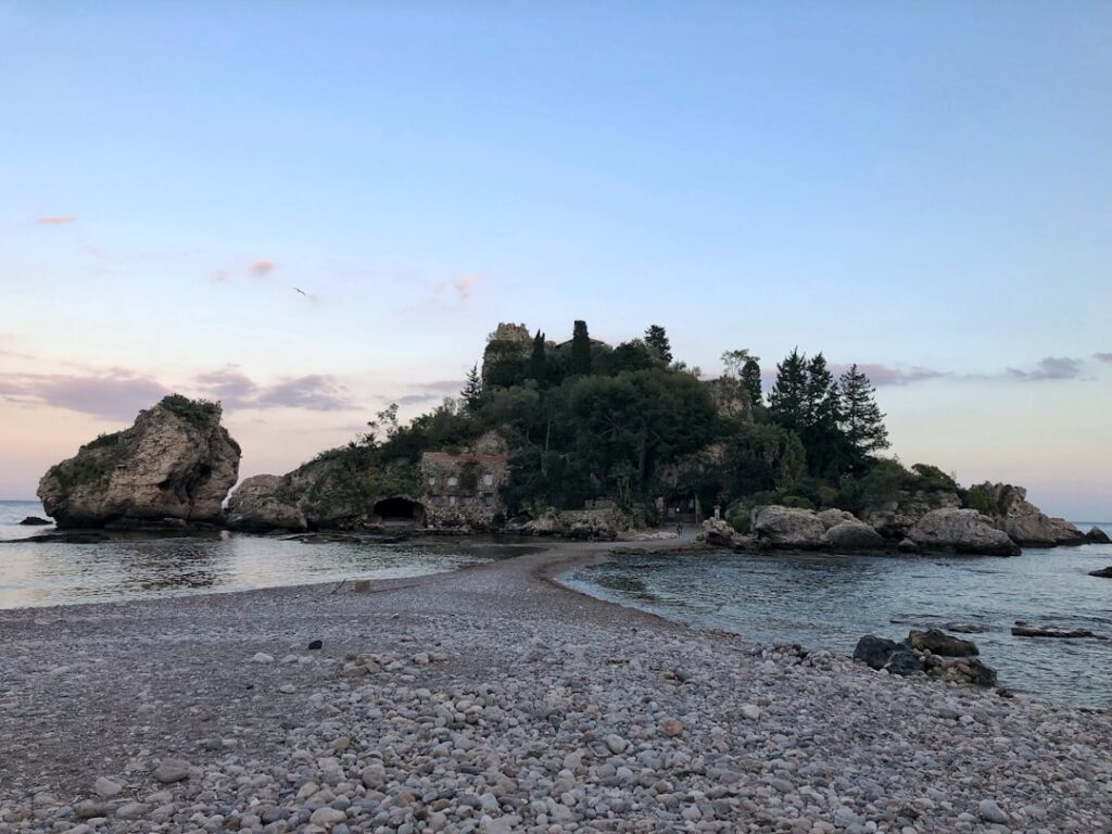 Tombolo de galets menant à l'îlot boisé d'Isola Bella, Sicile