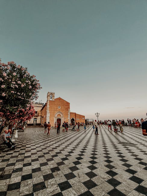 Großer Schachbrettplatz mit Kirche und Menschen in Taormina, Sizilien