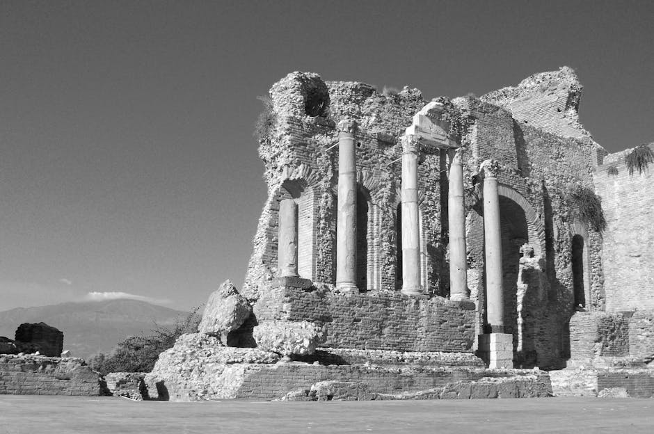 Ruines antiques à colonnes surplombant la côte sicilienne, volcan visible en arrière-plan