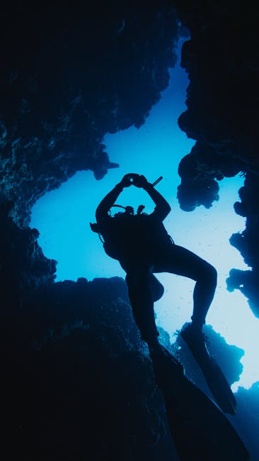 Subacqueo in silhouette esplora una grotta sottomarina in Sicilia