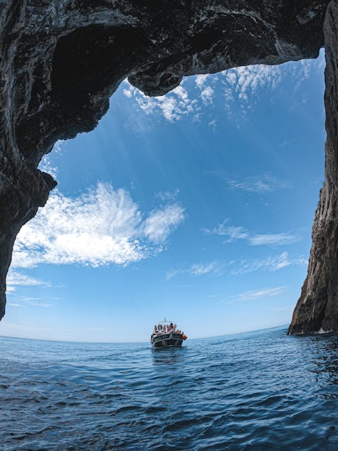 Bateau approchant d'une ouverture de grotte au large de Sicile