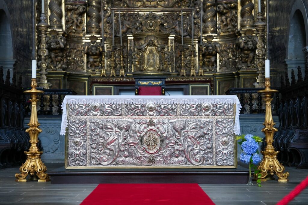 Altare barocco con dettagli dorati e tovaglia, interno di chiesa in Sicilia