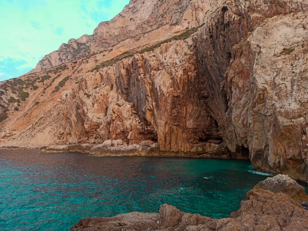 Felsklippen mit türkisem Meer und Meeresgrotte an der sizilianischen Küste