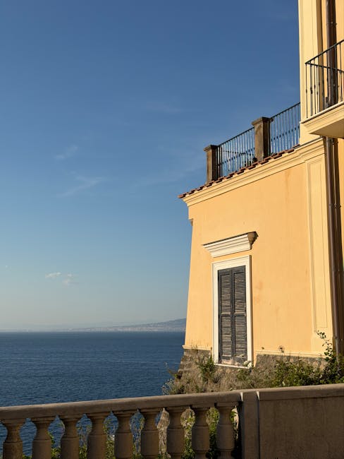 Yellow seaside villa facade overlooking Mediterranean sea in Sicily from terrace