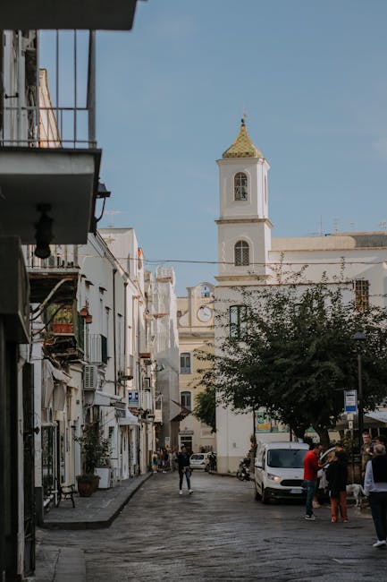 Narrow cobbled street leading to church tower in Mondello, Sicily
