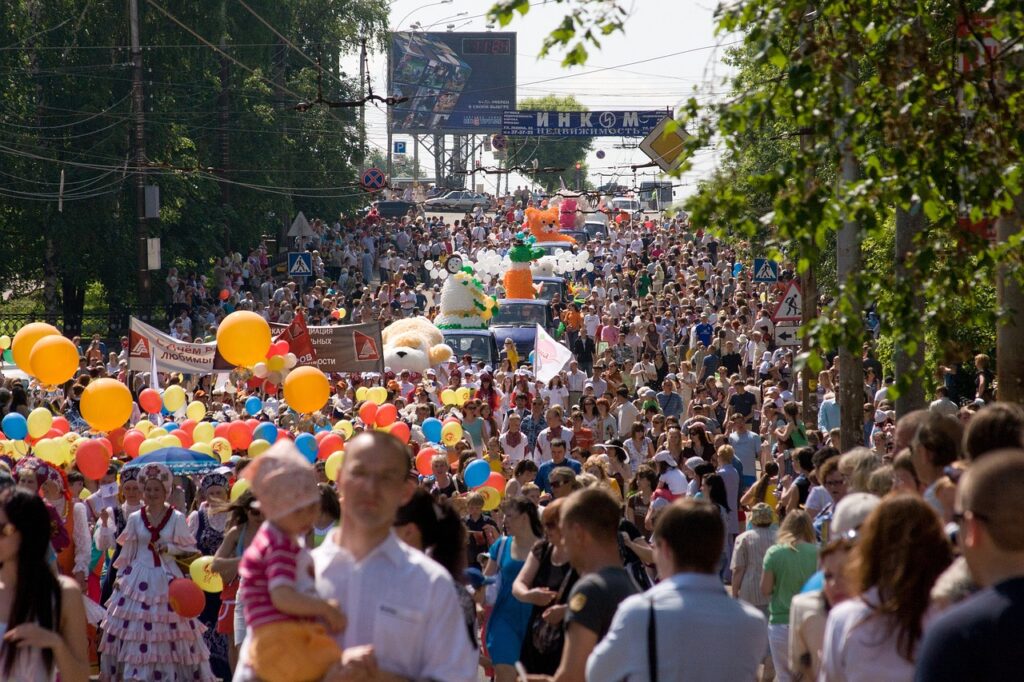 Lunga processione che avanza lungo Via Etnea a mezzogiorno