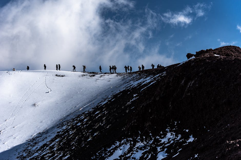 Silhouetten van wandelaars op besneeuwde kraterrand van Etna, Sicilië