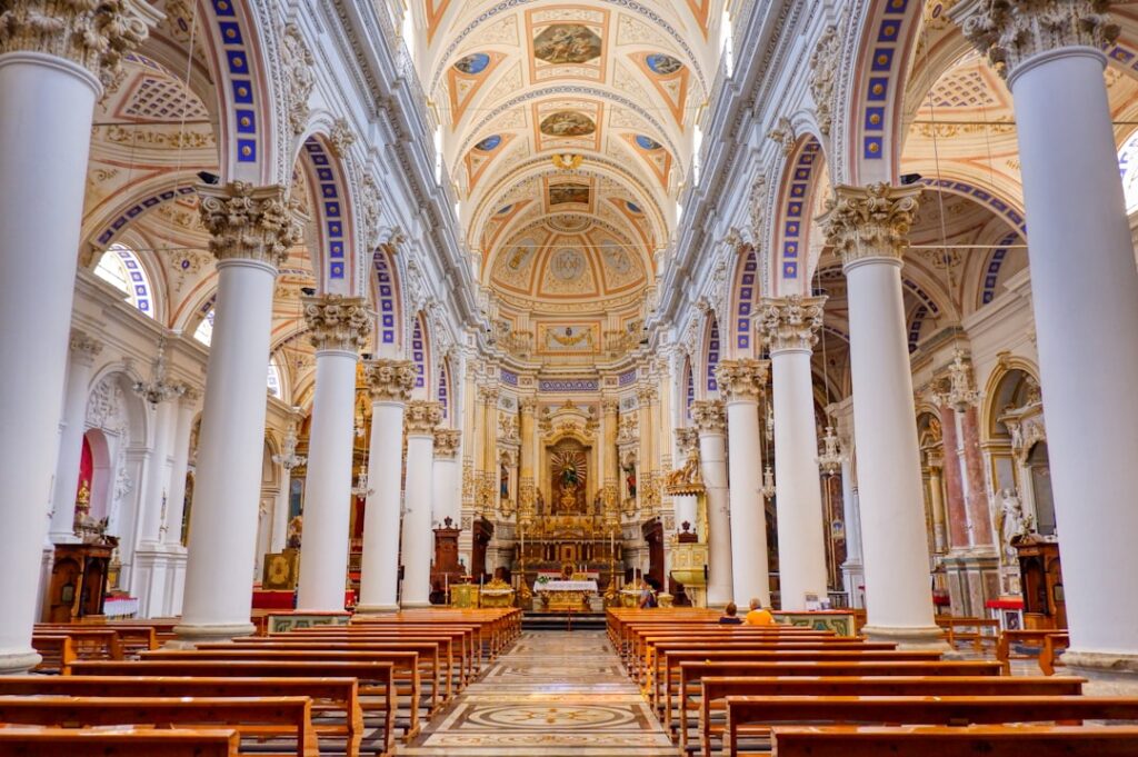 Ruimtelijk schip van kerk in Noto met hoge zuilen en fresco's