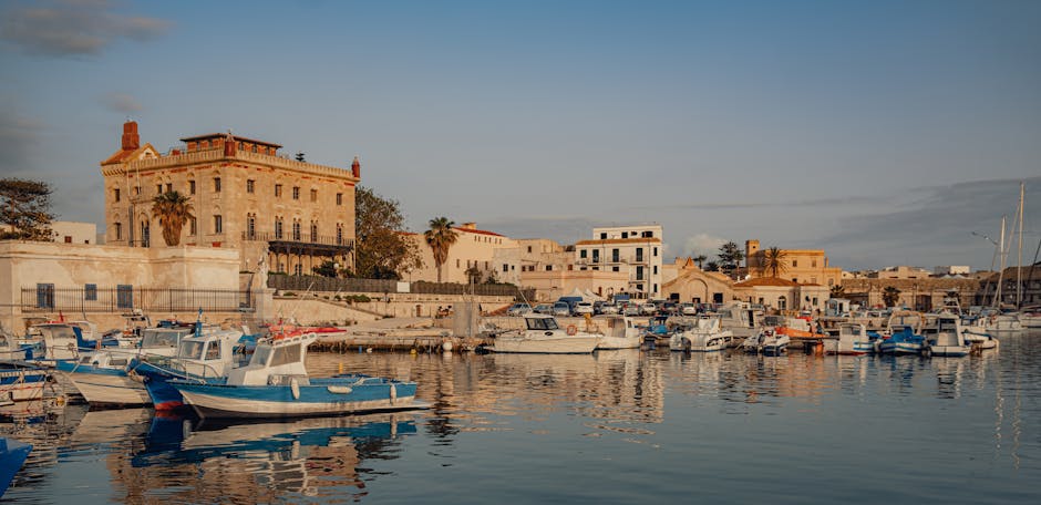 Hafen mit kleinen Fischerbooten und historischen Gebäuden in Sizilien