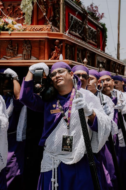 Portatori in tuniche viola sorreggono un fercolo decorato durante la festa a Catania