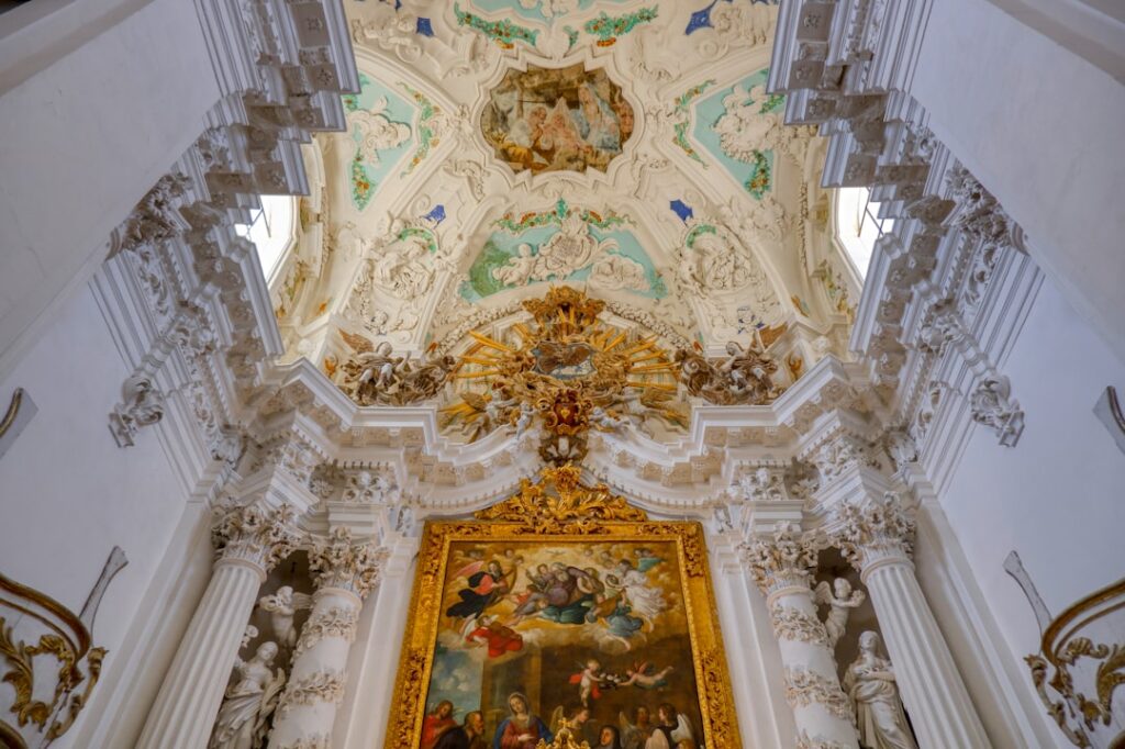 Gedetailleerd barok altaar met kleurrijk schilderij en stucwerkplafond in Noto