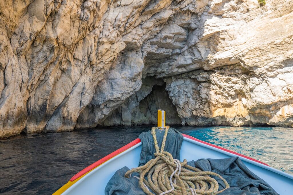 Proue d'une barque avec cordage entrant dans une grotte sicilienne