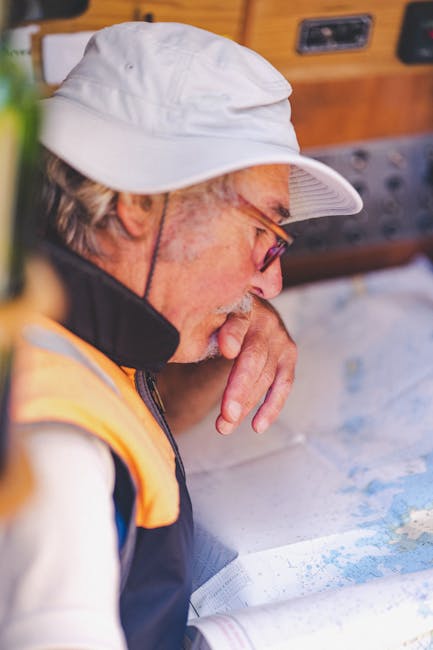 Skipper examinant une carte nautique à l'intérieur du bateau
