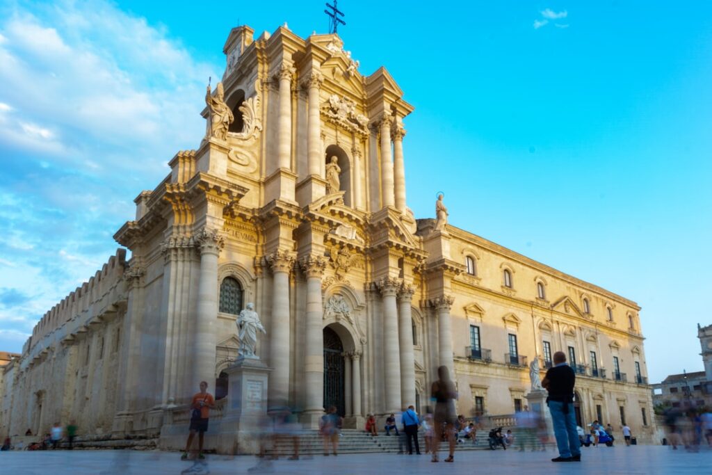 Barokke façade van de Duomo van Syracuse in Sicilië, mensen op plein