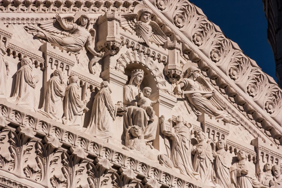 Detailed white marble relief depicting Madonna and angels on Sicilian façade