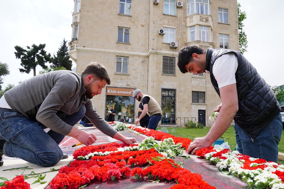 Artisans assemblant un tapis de fleurs rouge et blanc en Sicile