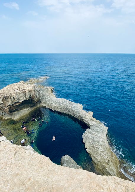 Arco roccioso che forma piscina naturale con bagnanti, Plemmirio Sicilia