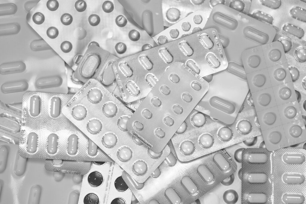 Assortment of empty and full pill blister packs scattered on surface