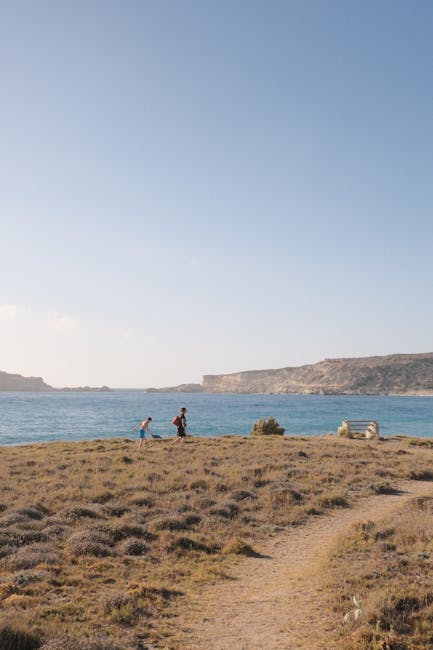 Due persone che camminano su promontorio panoramico verso il mare, Sicilia