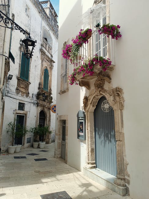 Ruelle pavée sicilienne avec balcon fleuri et portes anciennes