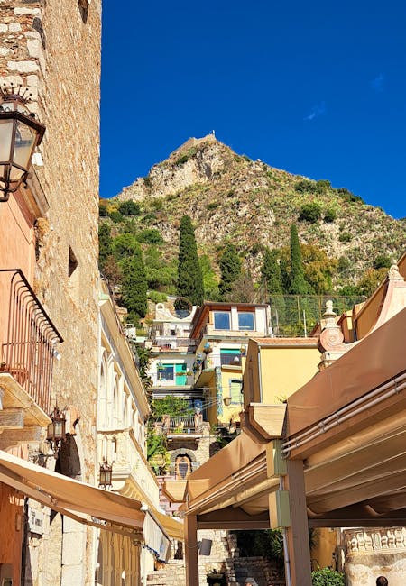 Colorful houses climbing a Sicilian hillside under deep blue sky