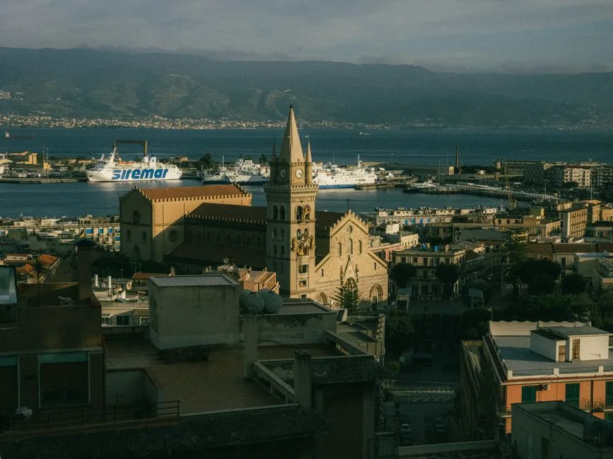 Vue sur le port sicilien avec cathédrale et ferries en arrière-plan