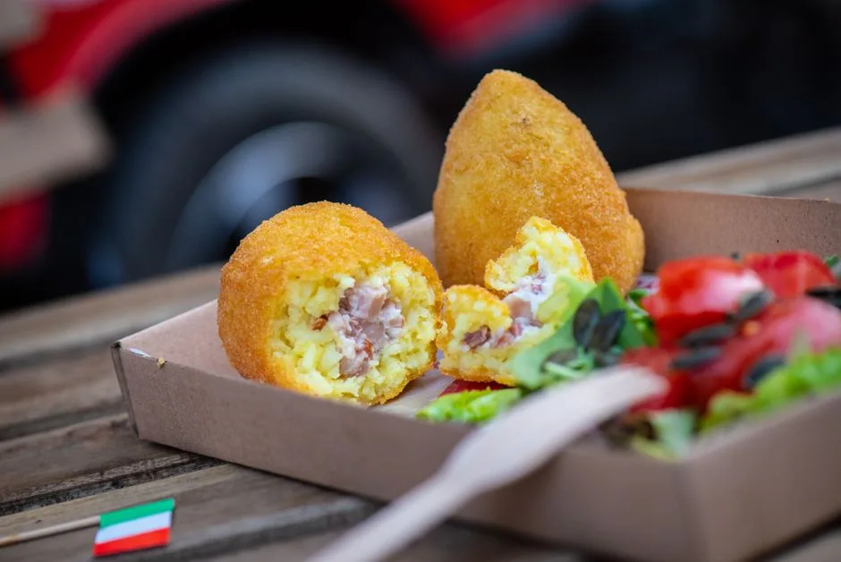 Arancini dorés coupés, servis avec salade, spécialité de Sicile