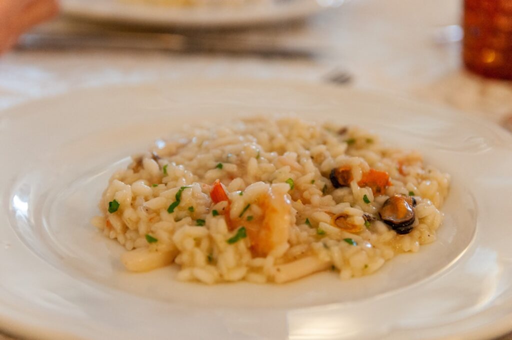 Creamy seafood risotto garnished with herbs, typical Lake Maggiore dish
