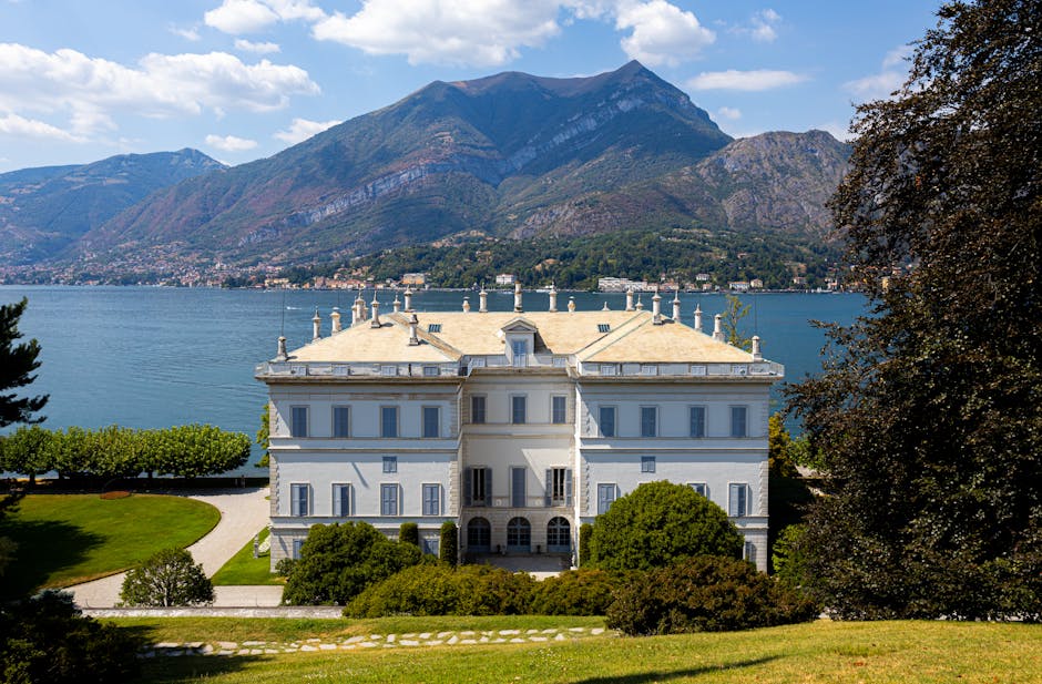 Neoclassical villa on Lake Maggiore shoreline with mountains behind.