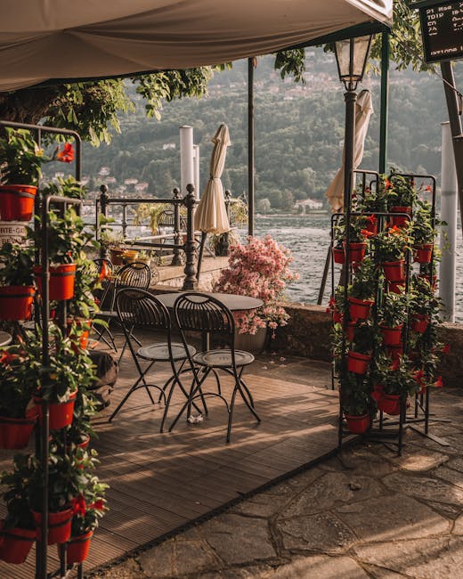 Terrasse fleurie d'un café au bord du Lac Majeur avec chaises vides