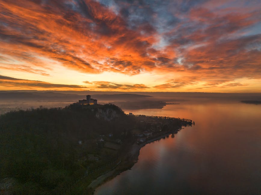 Luchtbeeld van landtong met kasteel boven Lac Majeur bij zonsopgang