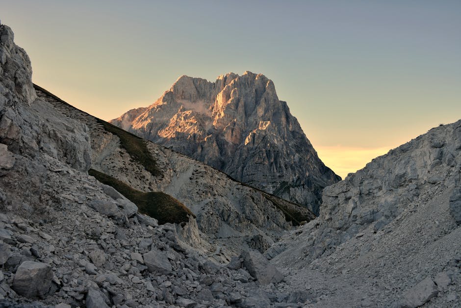 Sunlit craggy mountain peak framed by rocky valley near Lac Majeur
