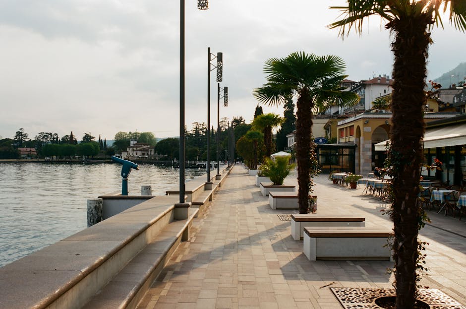 Spokojna promenada nad Jeziorem Maggiore z ławkami i latarniami