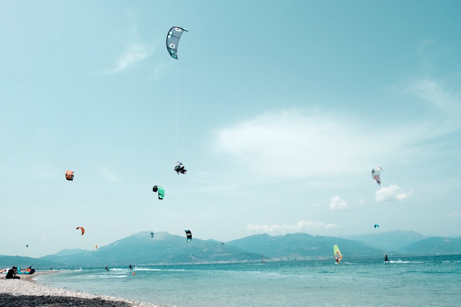 Plage et multiples kitesurfeurs face aux montagnes du Lac Majeur