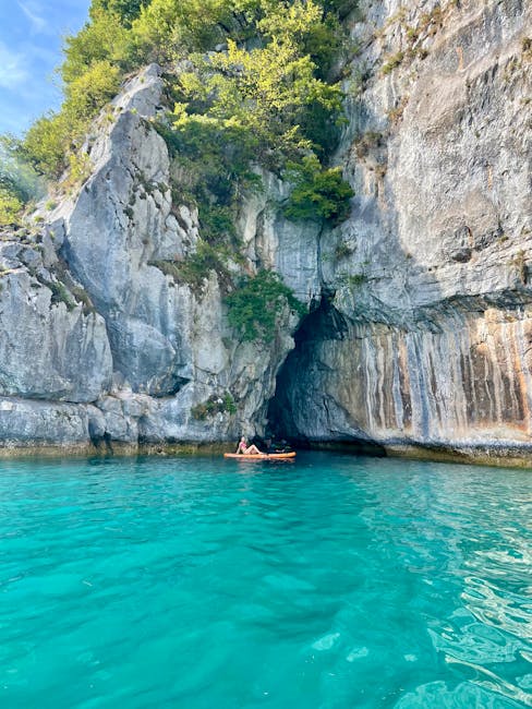 Kajakker bij rotsachtige grot en turquoise water op Lac Majeur