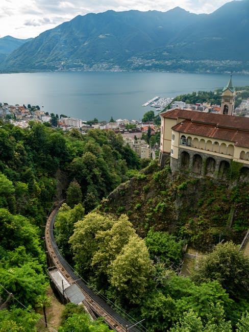 Häuser an steiler Klippe, Standseilbahn und weiter Blick auf den Lago Maggiore.