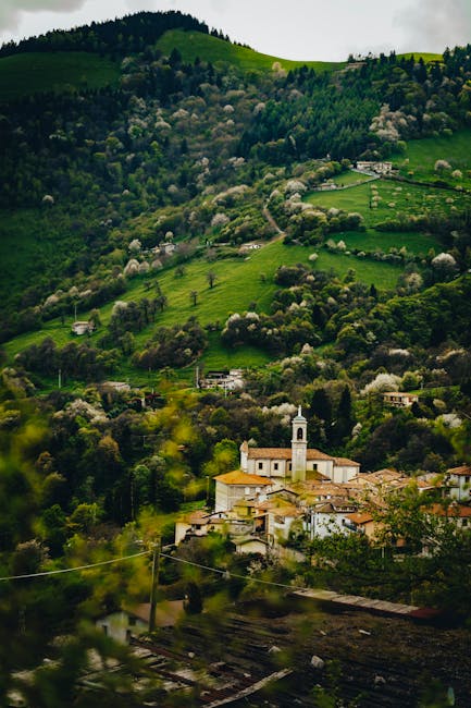 Village perché avec une église blanche, collines verdoyantes en arrière-plan