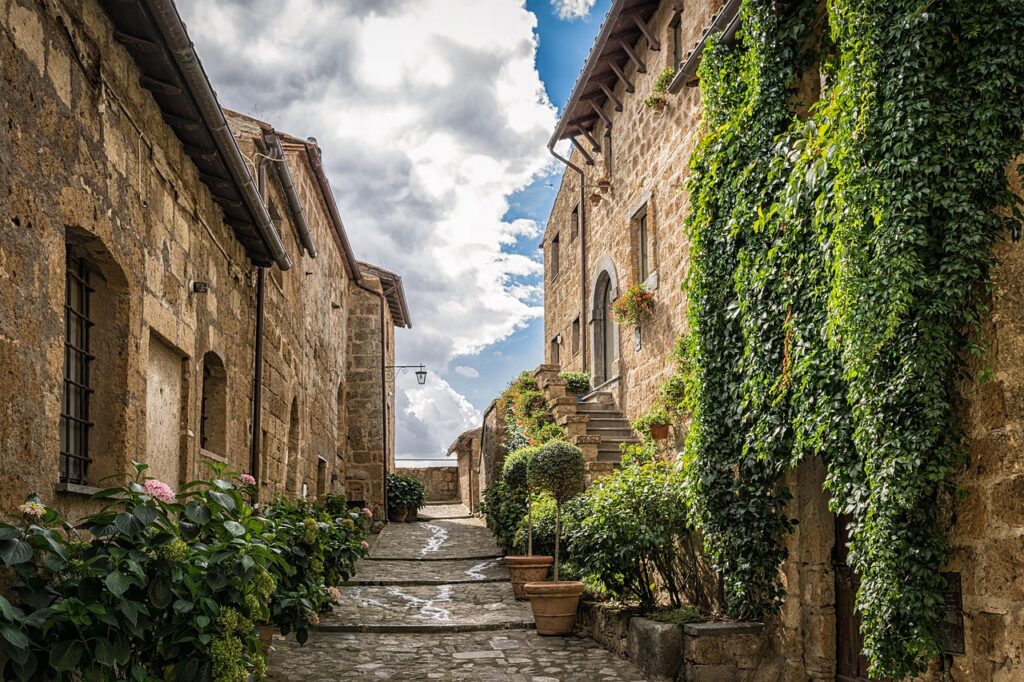 Ruelle de pierre bordée d'ifs et de pots de fleurs, charme ancien