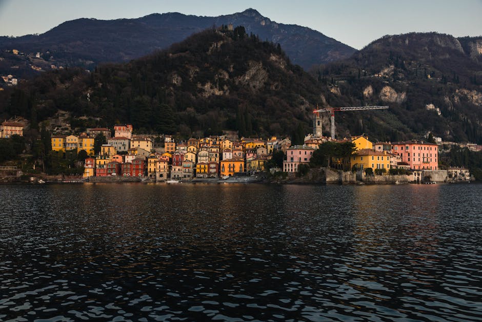 Façades colorées d'un village en bord du Lac Majeur, montagnes en arrière-plan