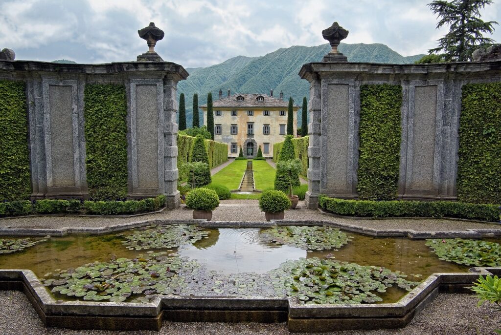 Walled Italian villa garden with lily pond and trimmed hedges near Lake Maggiore