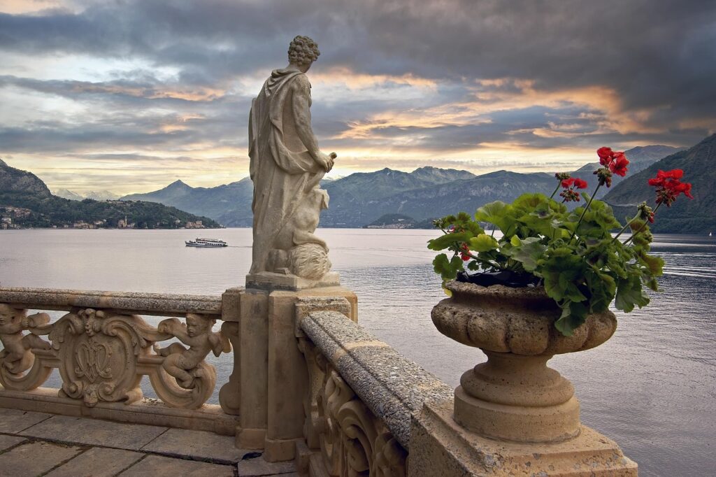 Stone terrace with statue and flower urn overlooking Lake Maggiore and distant mountains