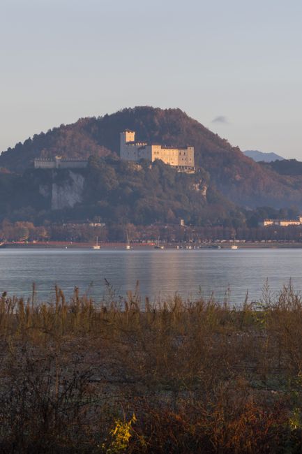 Hilltop castle overlooking Lake Maggiore with boats on calm water
