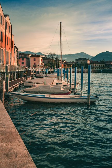Barche ormeggiate al molo davanti ai palazzi sul Lago Maggiore
