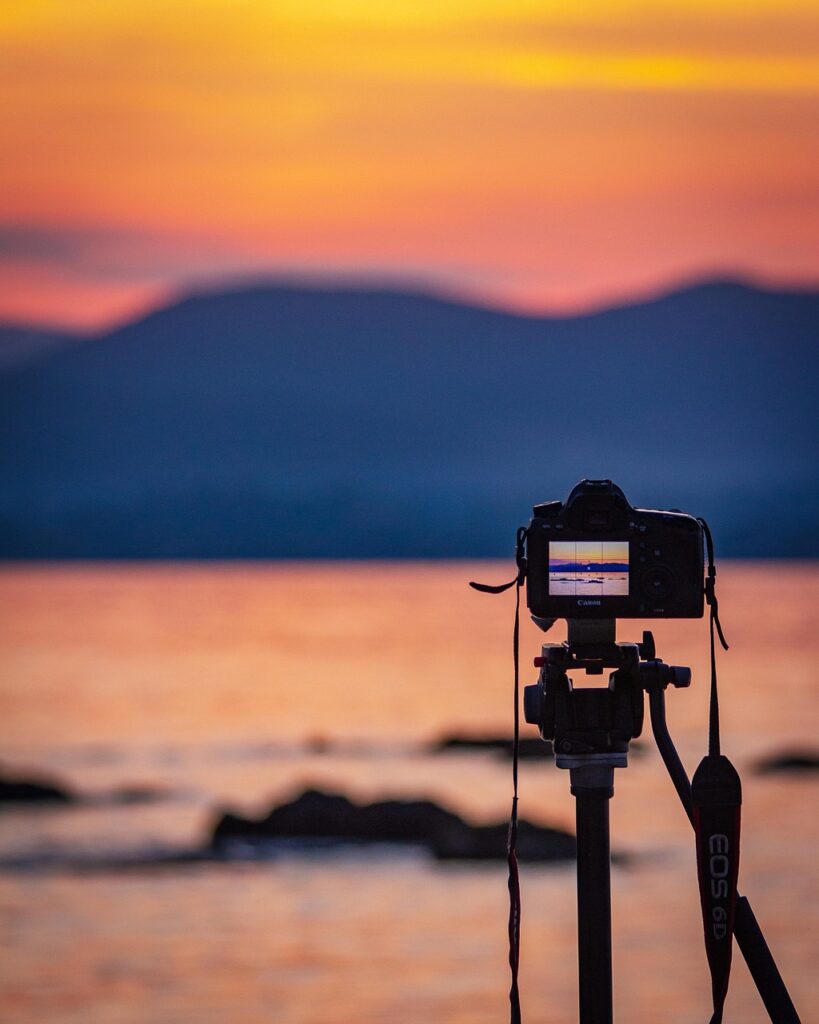 Appareil photo sur trépied photographiant le lever de soleil du Lac Majeur