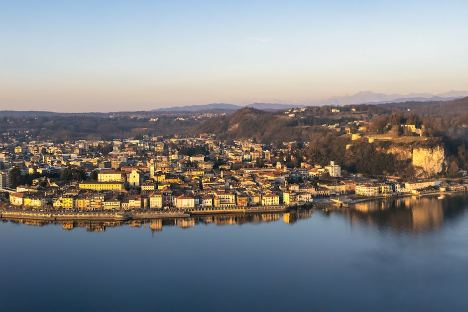 Città sul Lago Maggiore con lungolago e riflessi dorati al tramonto