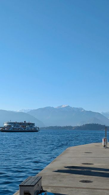 Ferry approaching pier with Alps behind on Lake Maggiore