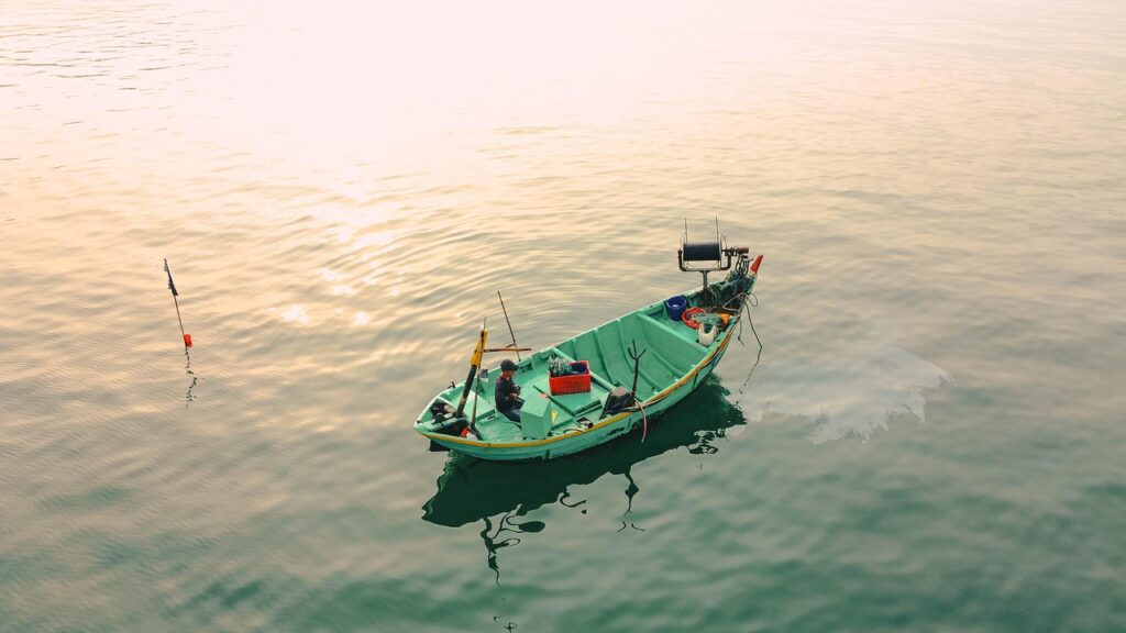 Petite barque de pêche verte flottant sur le Lac Majeur au matin