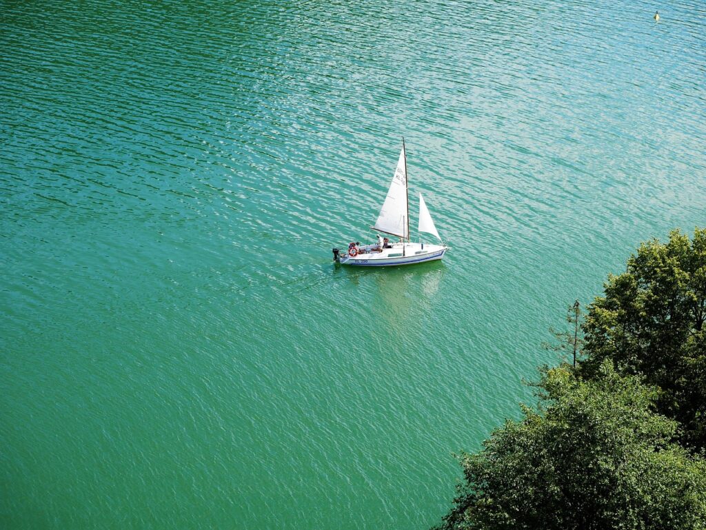 Monotipo a vela che naviga sulle acque verdi del Lago Maggiore
